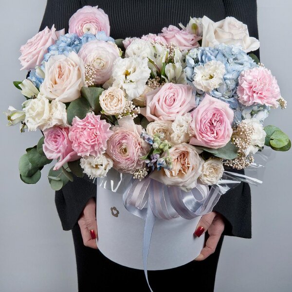 Blue/purple hydrangea - 2, Peony style roses - 3, Ranunculus Pink - 3, lisianthus - 3, Pink carnation - 5, Alstromeria white, soft pink - 7, Peony sprayrose - 2, Peony rose pink 'OHara' - 3, Round flower box medium, Oasis, Ozotamnus, Oksipetalum, Eucalyptus, Ribbon